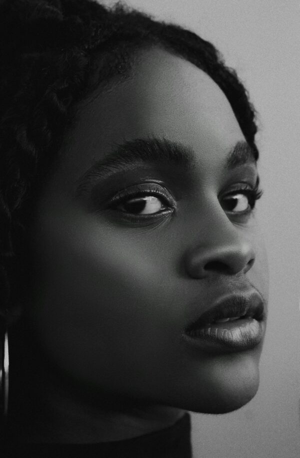 Black and white close-up portrait of a young woman with a focus on beauty and emotion.
